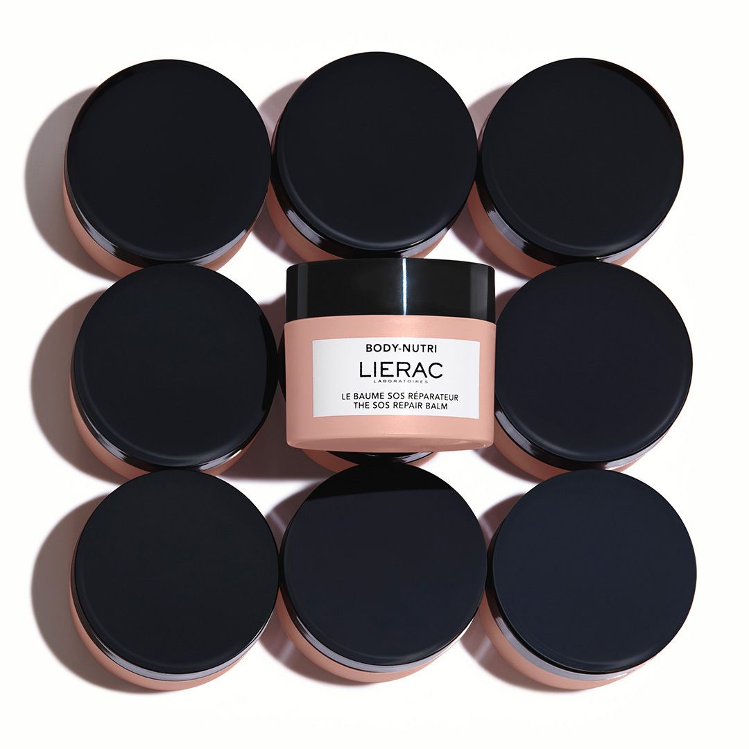 Pot rose avec couvercle noir. Inscription : Lierac, Body-Nutri, Le Baume SOS Réparateur. Étiquette blanche.