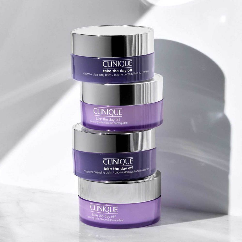 Quatre pots CLINIQUE Take the Day Off, empilés. Pots violets avec couvercles argentés.