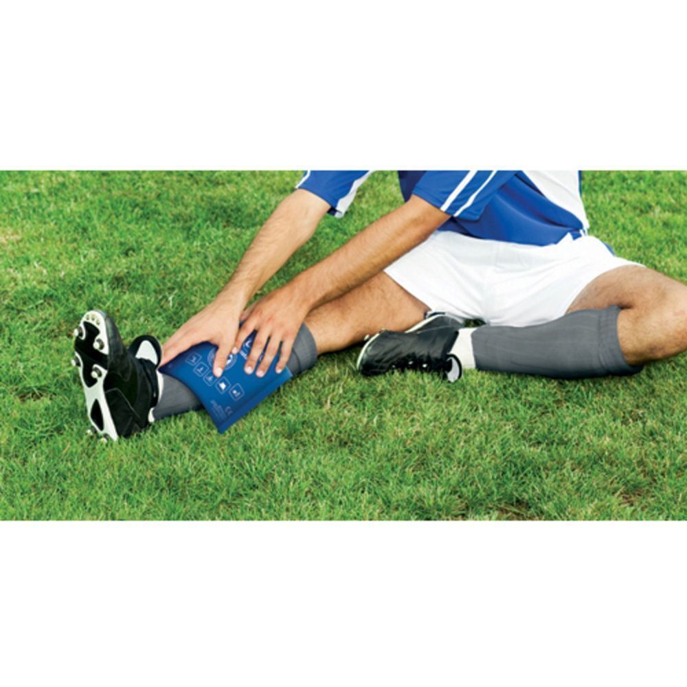 Un homme avec un pack Nexcare Cold Instant Therapy sur la jambe sur l'herbe.