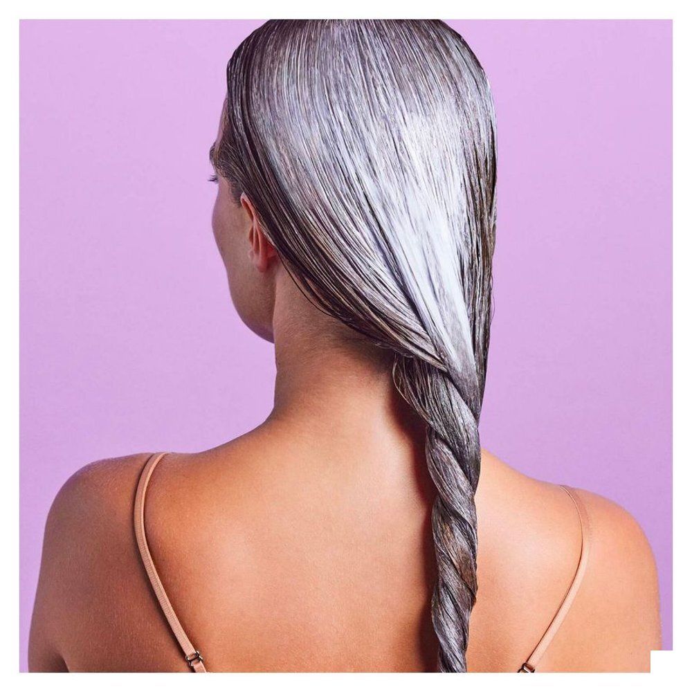 Femme aux cheveux tressés couverts de soin.