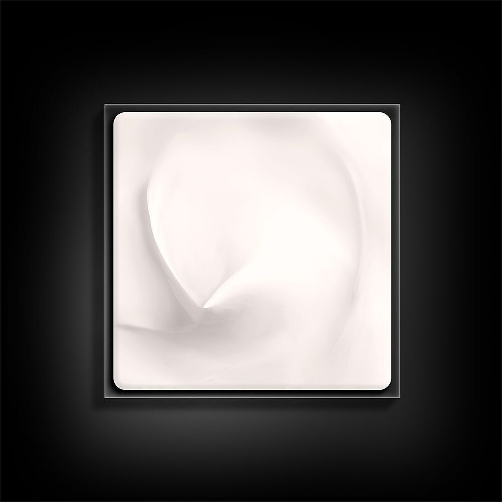 Crème dans un récipient carré. La crème est blanche et a une surface lisse.