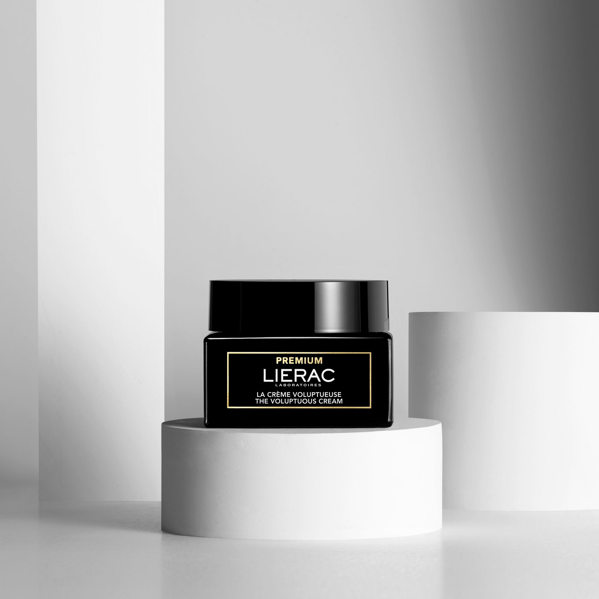 Pot noir sur socle blanc. Inscription: LIERAC, PREMIUM, LA CRÈME VOLUPTUEUSE, THE VOLUPTUOUS CREAM.