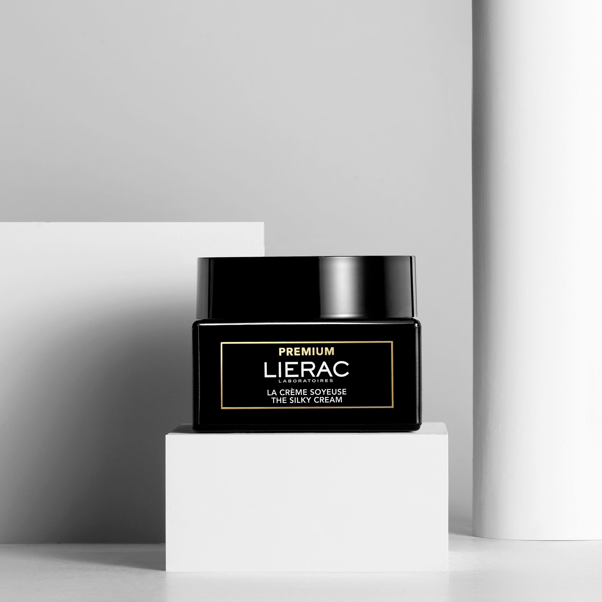 Pot noir sur tissu blanc. Inscription : LIERAC PREMIUM, LA CRÈME SOYEUSE, THE SILKY CREAM.