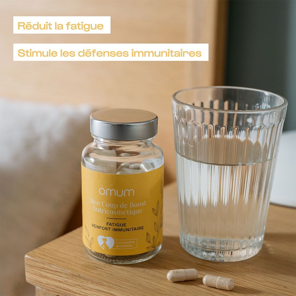 Produit avec flacon en verre et verre d'eau. Inscription: Omum Mon Coup de Boost Nutricosmétique. Gélules.