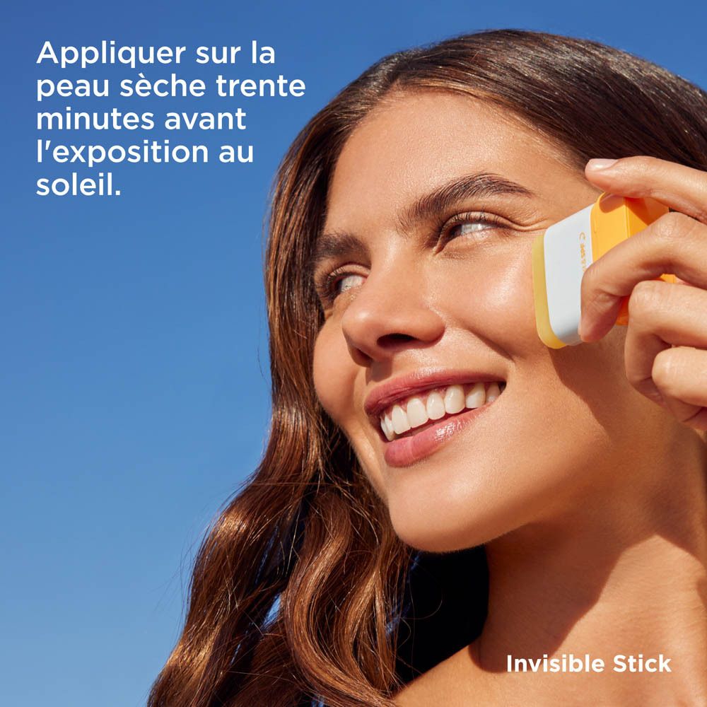 Femme appliquant ISDIN Fotoprotector Invisible Stick. Texte: Appliquer sur la peau sèche.