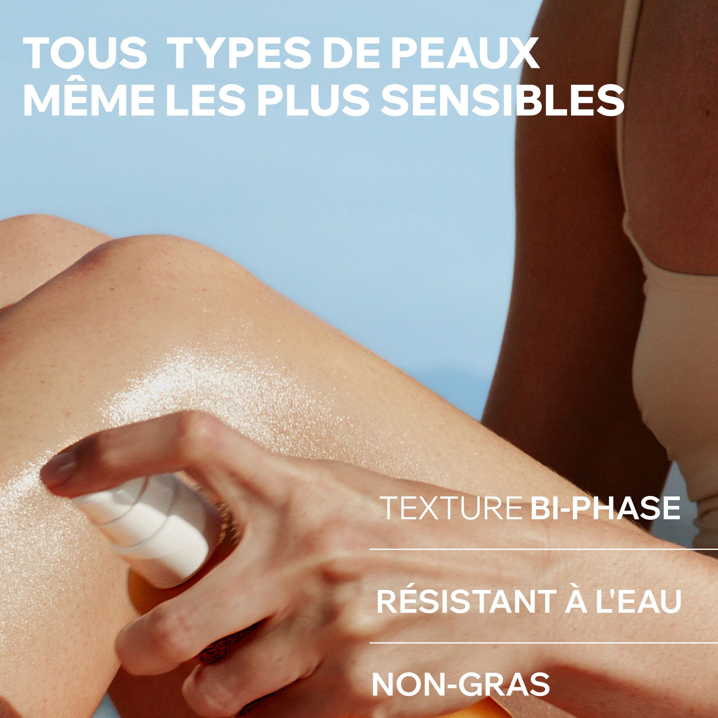 Uriage Bariésun Eau Solaire Fraîche SPF50+ spray. Femme vaporisant le produit sur sa jambe. Fond bleu.