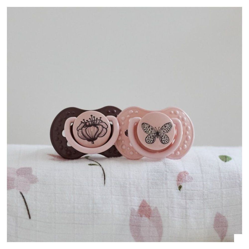 Sucette rose avec motif papillon.