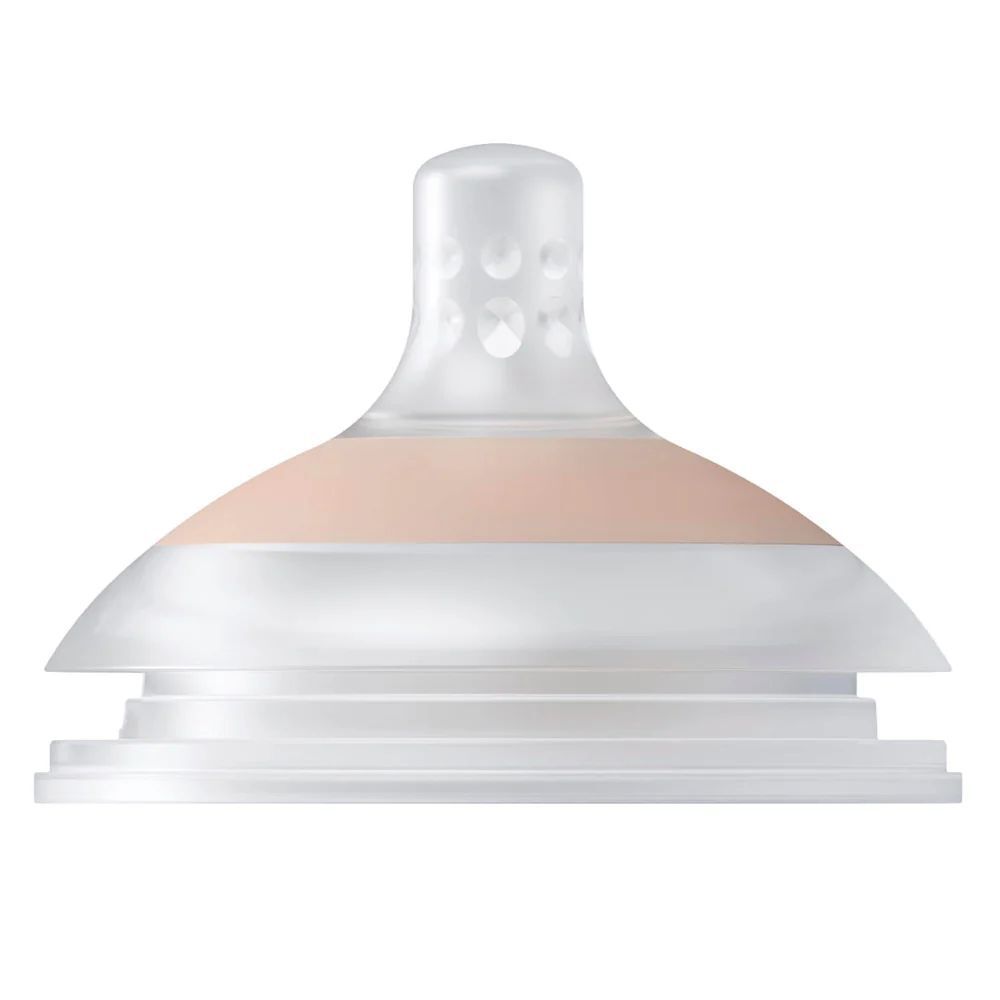 Tétine en silicone transparente avec base rose. Petites ouvertures en haut.