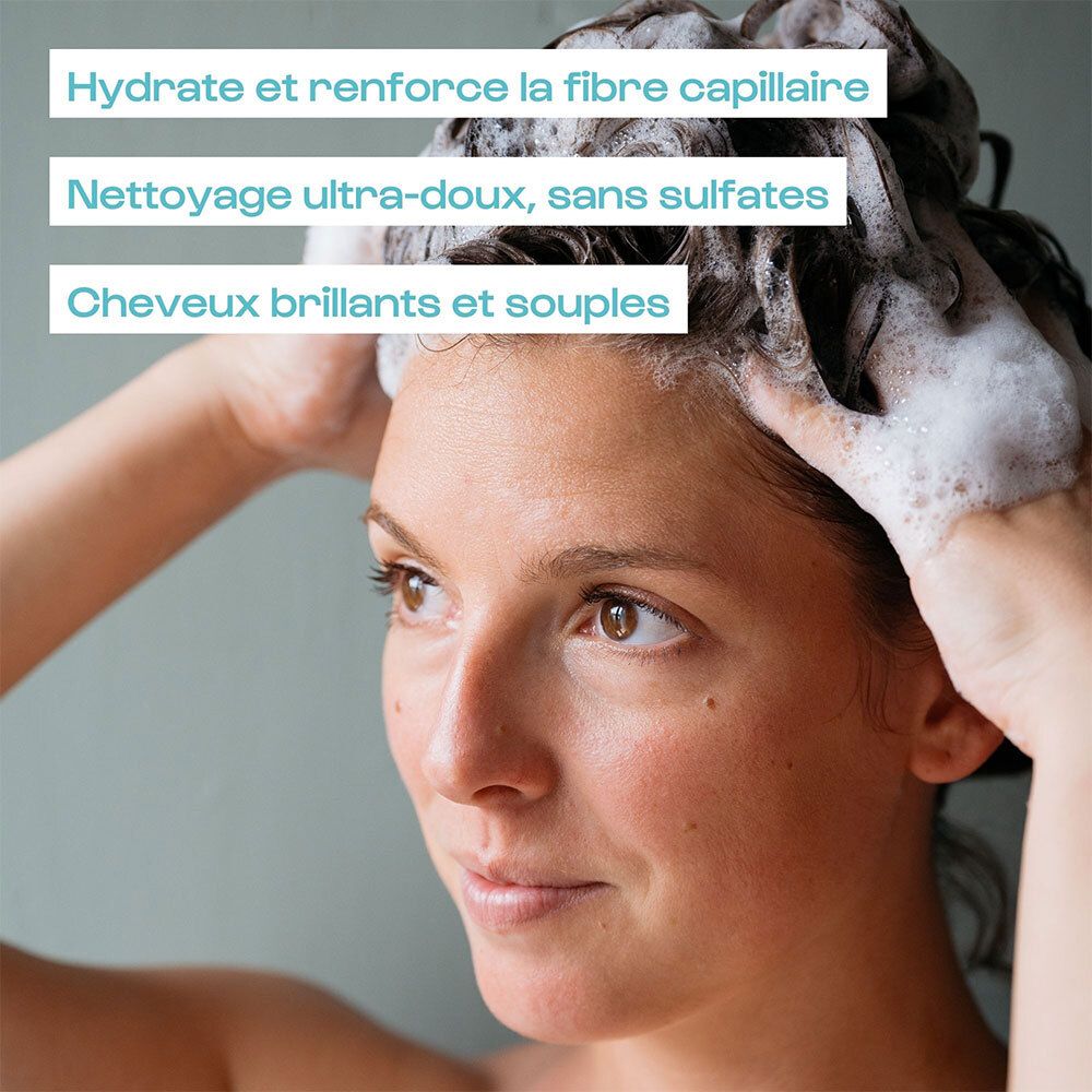 Femme se lave les cheveux. Texte : Hydrate, renforce la fibre capillaire, nettoyage doux, cheveux brillants.