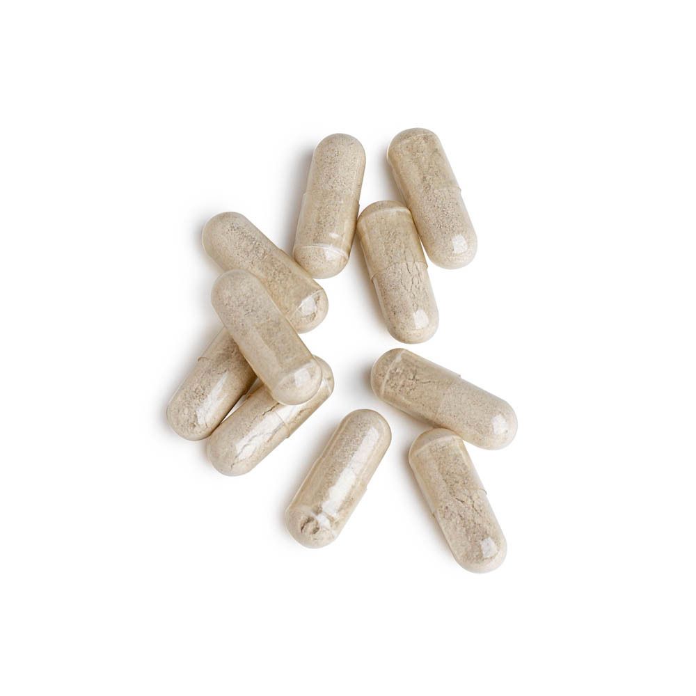 Gros plan de plusieurs gélules. Gélules transparentes avec contenu clair. Sur fond blanc.