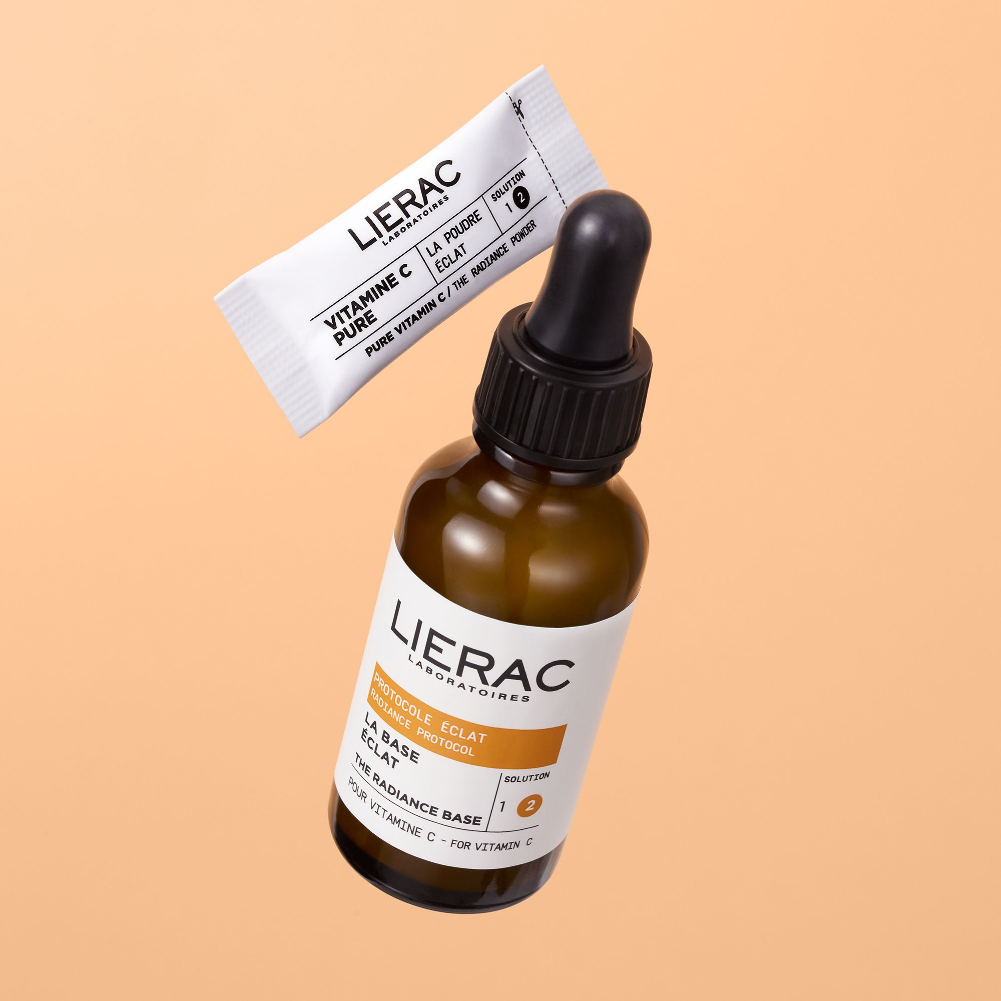Flacon brun avec pipette et sachet blanc. Logo LIERAC et noms de produits visibles.