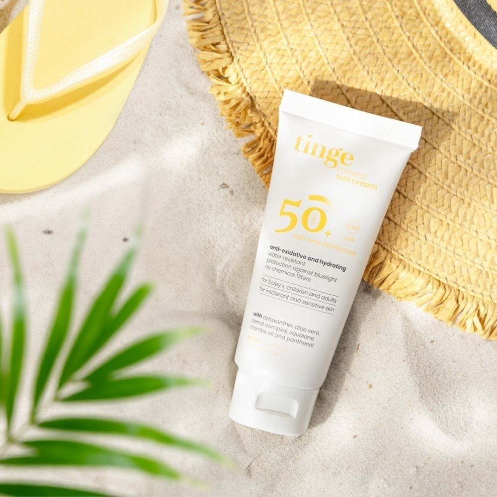 Tinge Crème Solaire Minérale SPF50+ sur le sable.