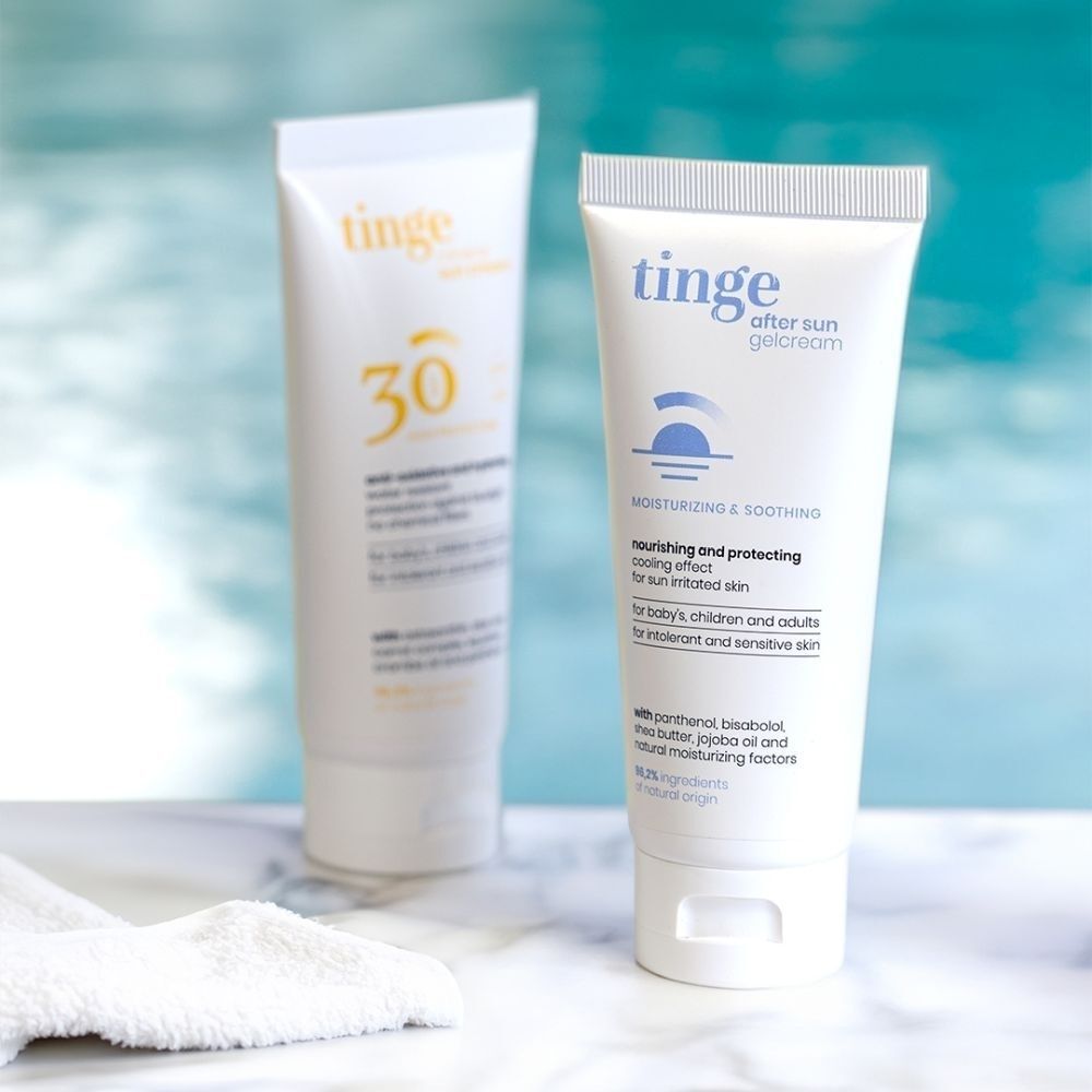 Deux tubes de Gel-Crème Après-Soleil Tinge près d'une piscine.