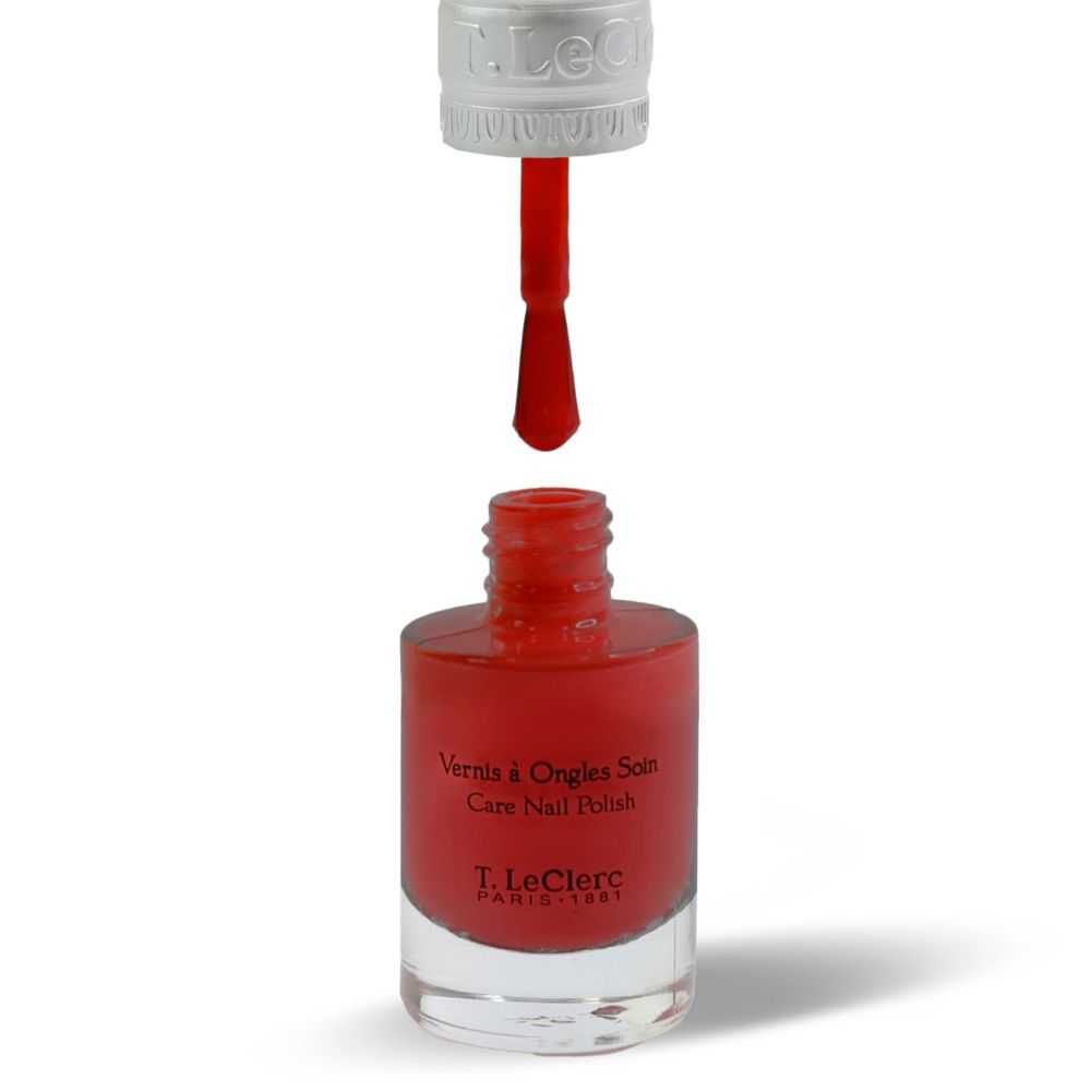 Flacon de vernis à ongles rouge avec pinceau. Flacon ouvert, pinceau avec vernis rouge.