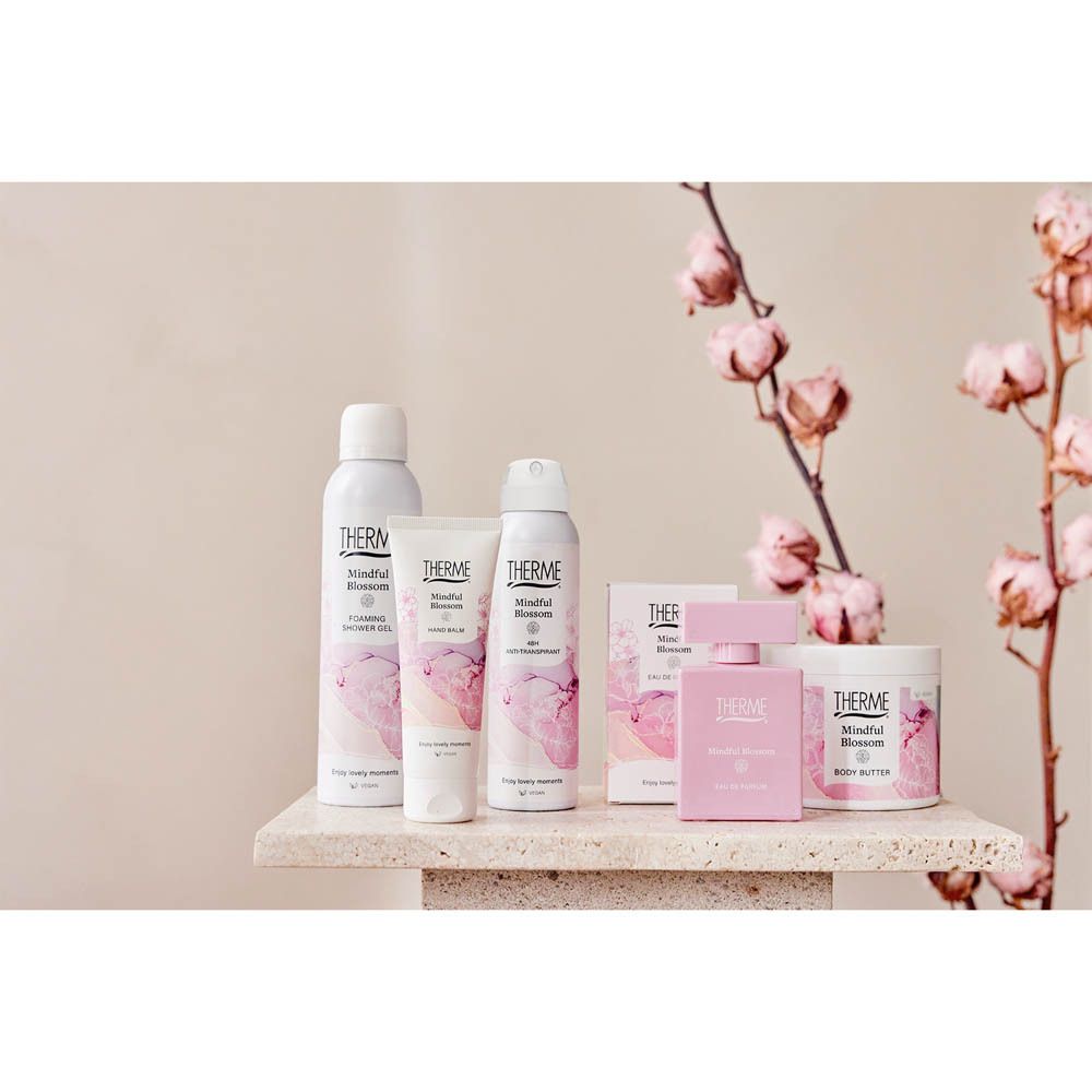 Produit dans un environnement de salle de bain. Gommage douche Therme Mindful Blossom sur une table.