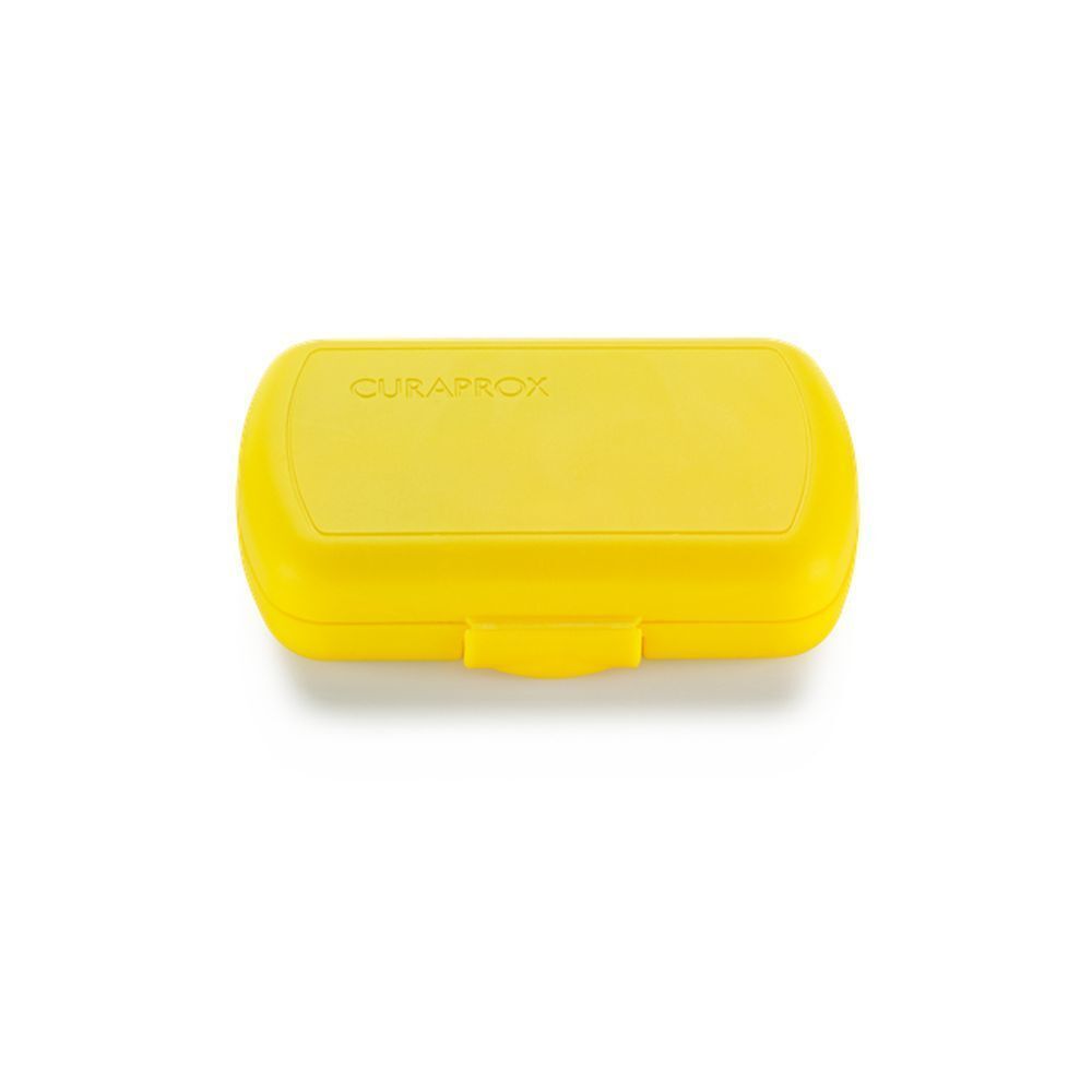 Boîte de trousse de voyage jaune fermée. Logo Curaprox sur le dessus.