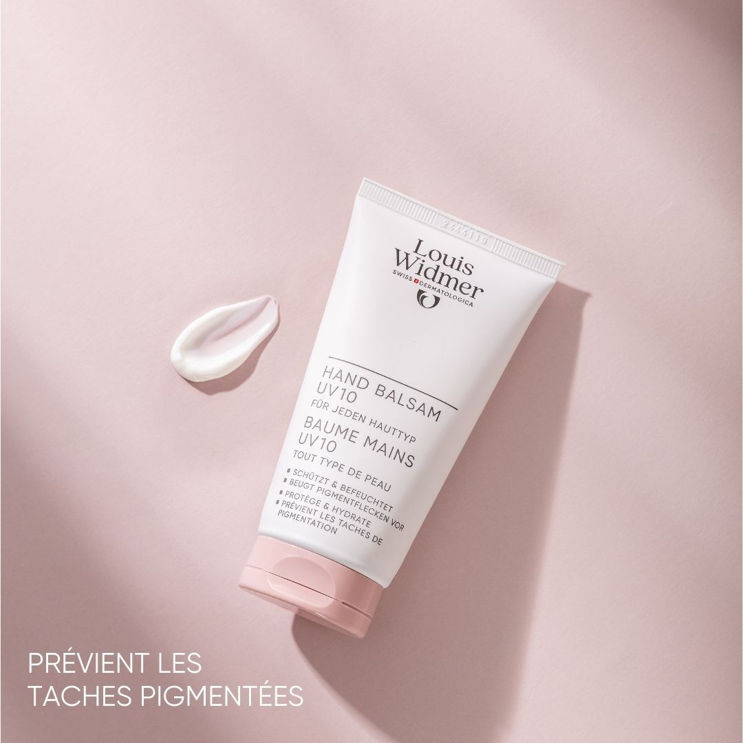 Tube blanche avec bouchon rose et une goutte de crème à côté. Inscription: Louis Widmer, Baume Mains UV10.