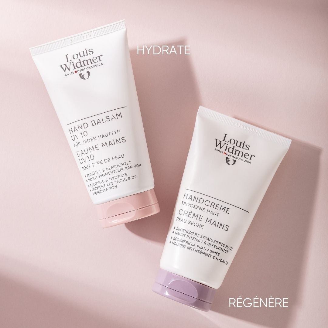 Deux tubes sur fond rose. Un avec bouchon rose, l'autre avec bouchon violet. Inscription: Baume Mains UV10 et Crème Mains.