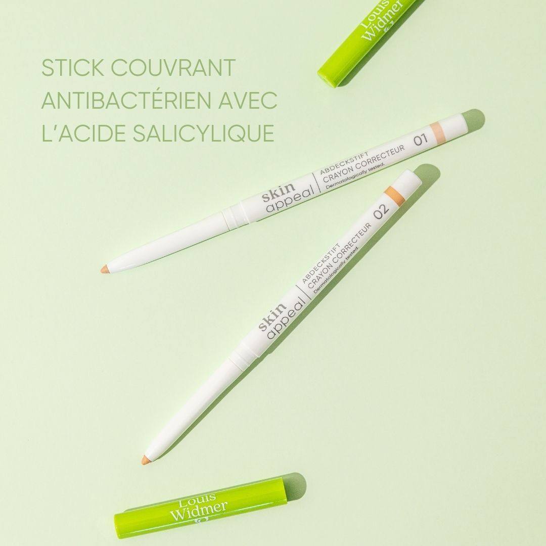 Coverstick 02 et emballage. Étui blanc avec nom du produit, crayon vert et blanc. Touche de couleur.