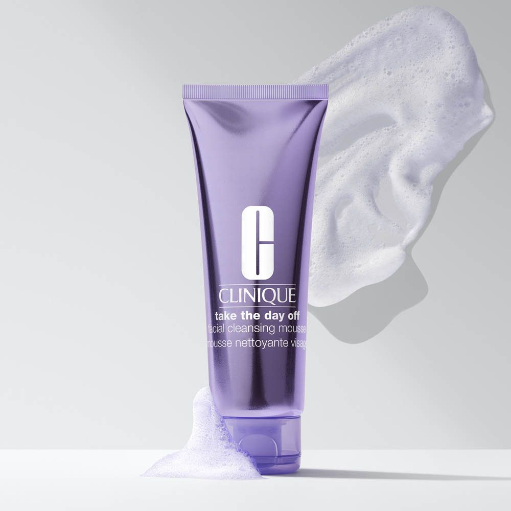 Mousse nettoyante visage Clinique Take The Day Off dans un tube violet avec de la mousse.