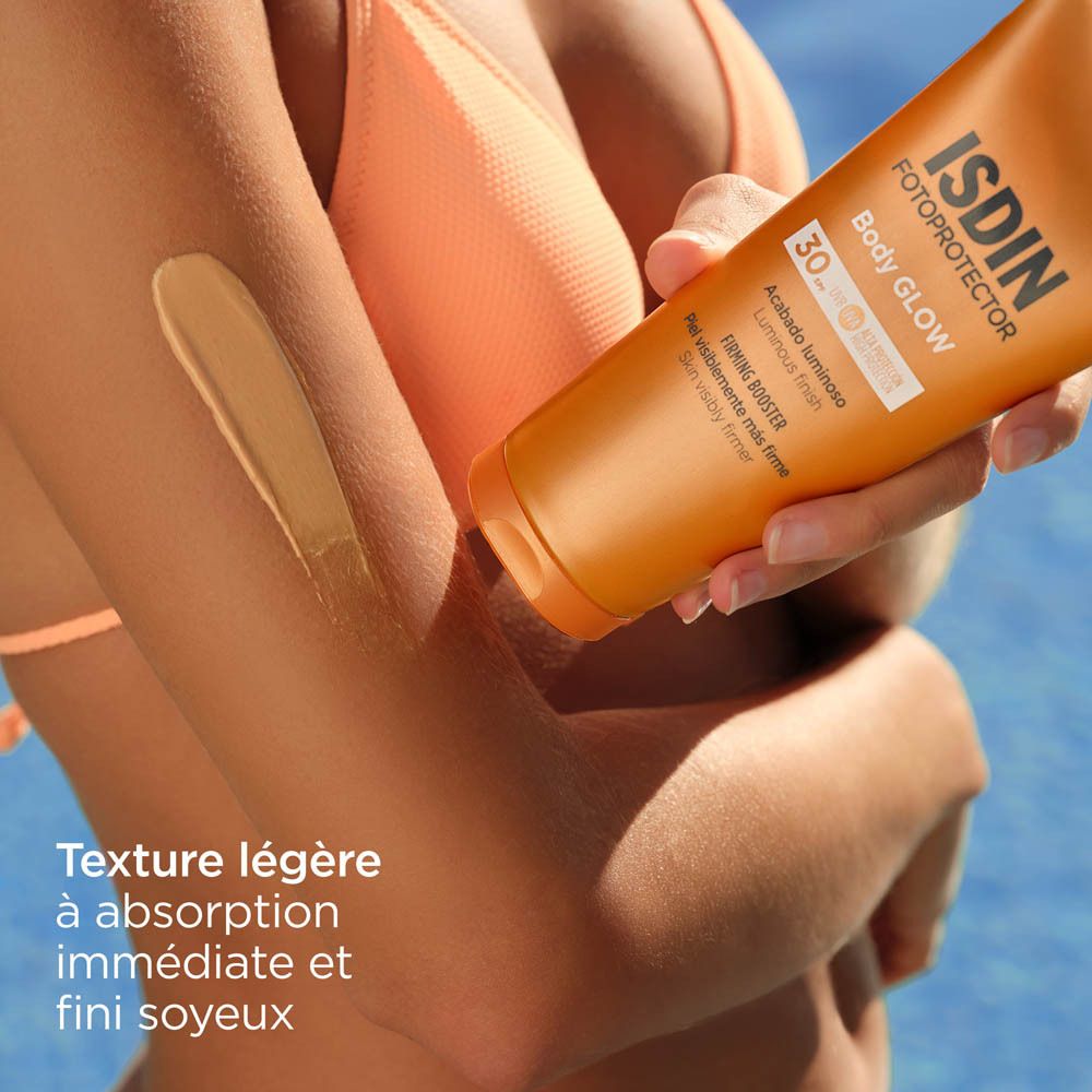 Bras avec crème ISDIN Body Glow appliquée. Texte: Texture légère, absorption immédiate, fini soyeux.