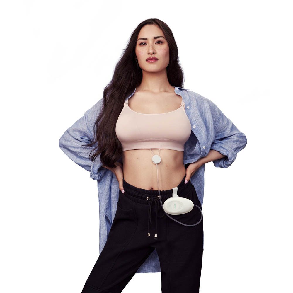 Une femme avec la pompe double Elvie Stride. Elle porte un haut et un pantalon. Le moteur est attaché au pantalon.