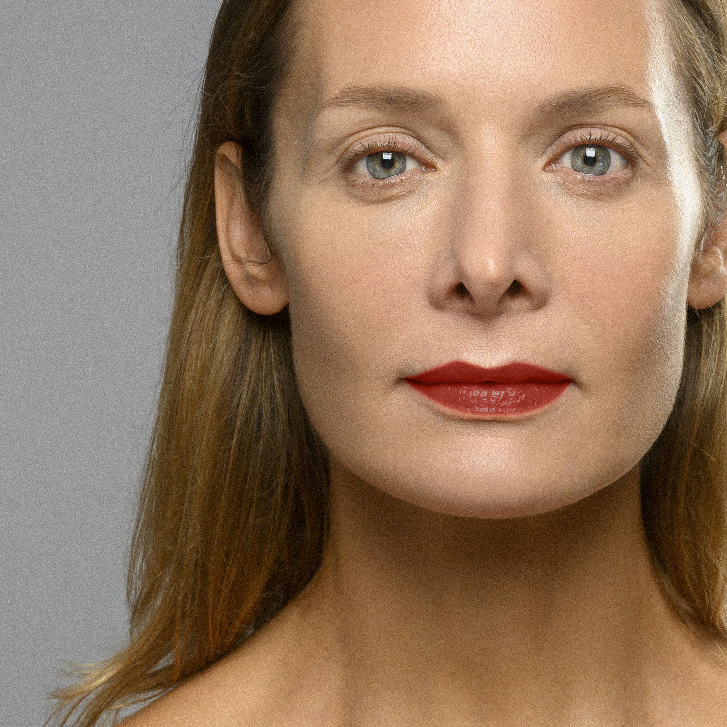 Portrait d'une femme portant du rouge à lèvres rouge. Teint clair, cheveux blonds. Couleur Anna 73.
