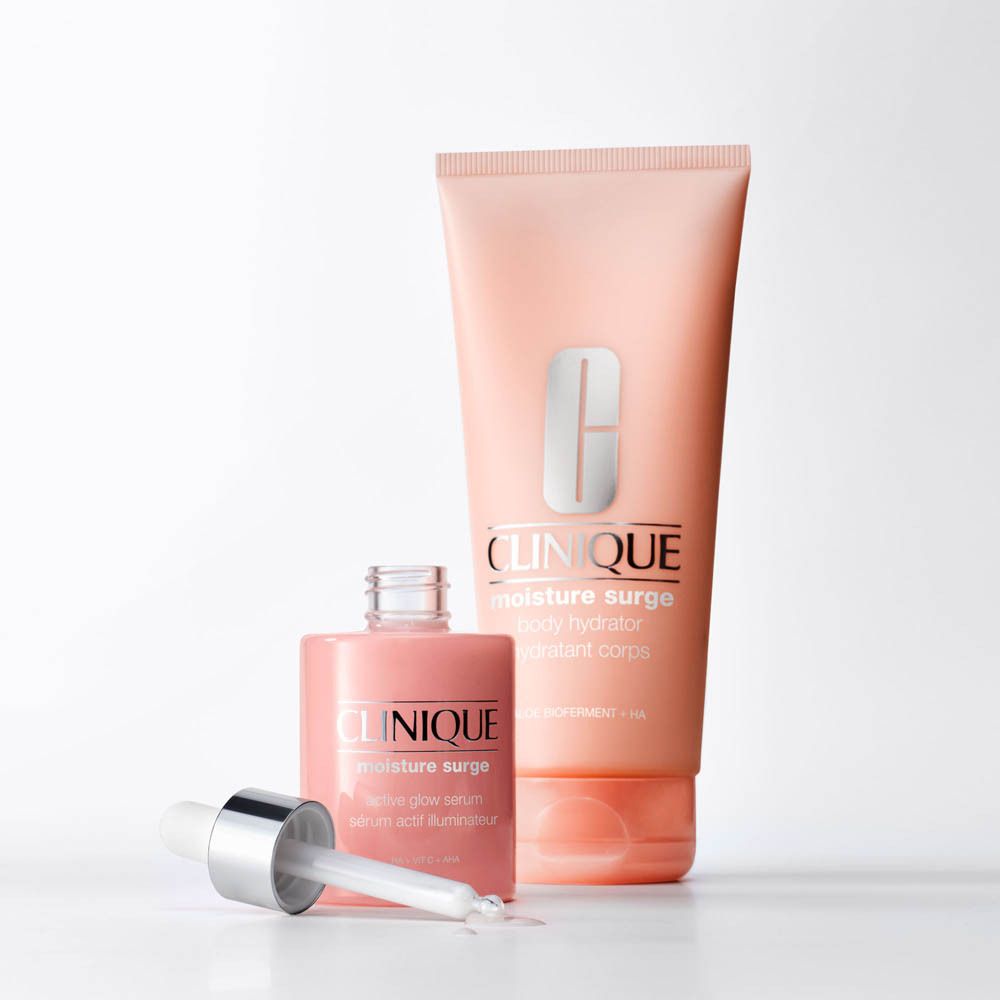 Femme tenant un tube Clinique Moisture Surge Body Hydrator.