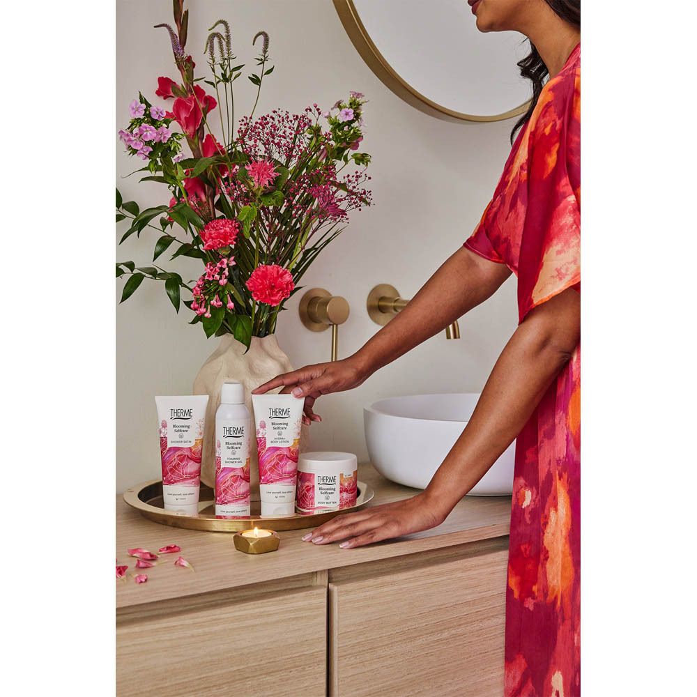 Produits sur un plateau. Personne en robe rouge. Bouquet de fleurs en arrière-plan.