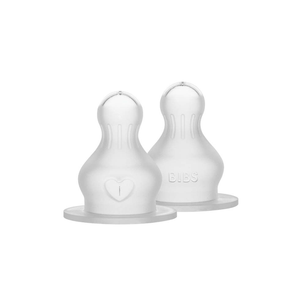 Deux tétines en silicone transparentes. Détail en forme de cœur. Logo BIBS. Forme ronde.