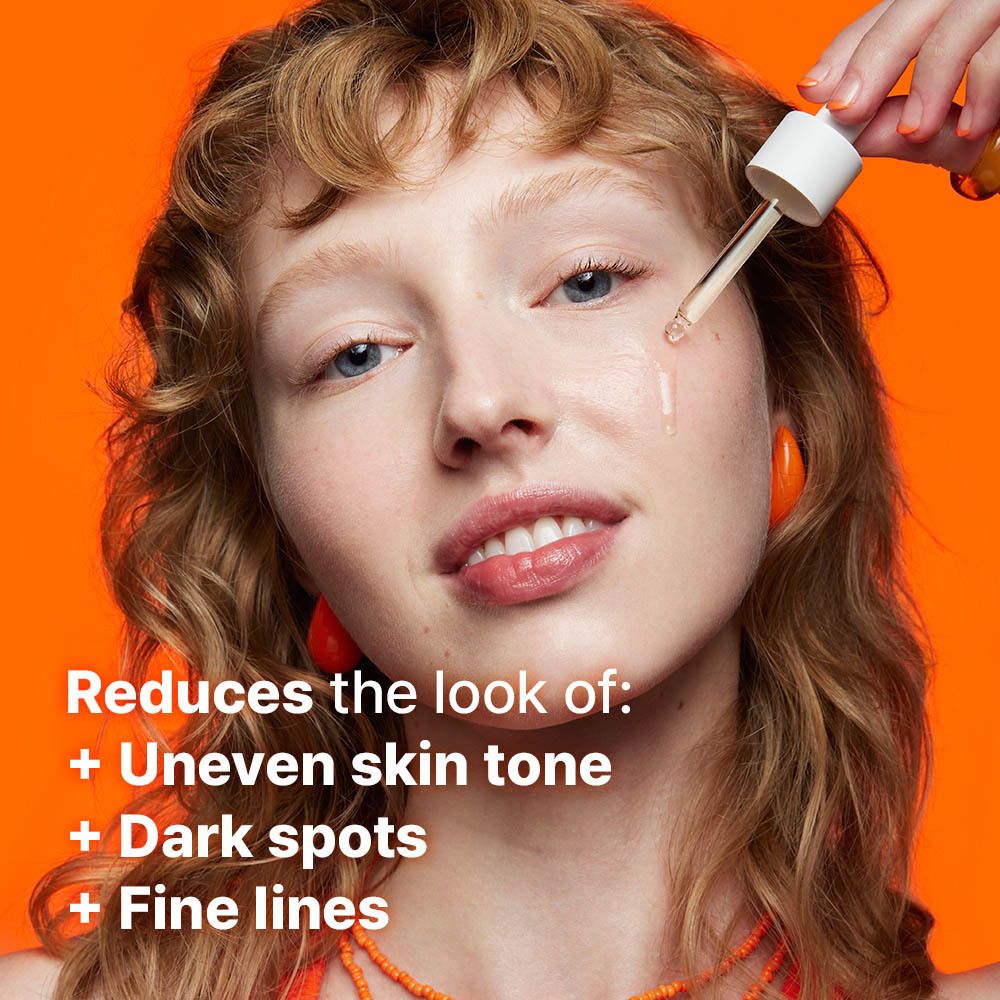 Femme appliquant du sérum sur le visage avec une pipette. Texte : Réduit l'apparence de : teint inégal, taches sombres, ridules.