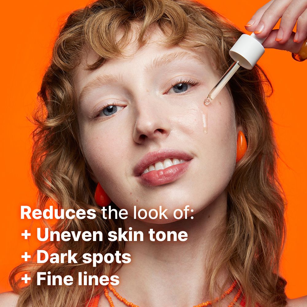 Femme appliquant du sérum sur le visage avec une pipette. Texte : Réduit l'apparence de : teint inégal, taches sombres, ridules.