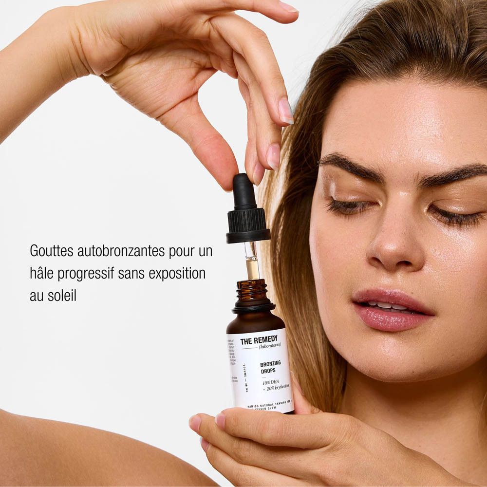 Femme tenant un compte-gouttes au-dessus du flacon. Texte : Teint progressif sans soleil.