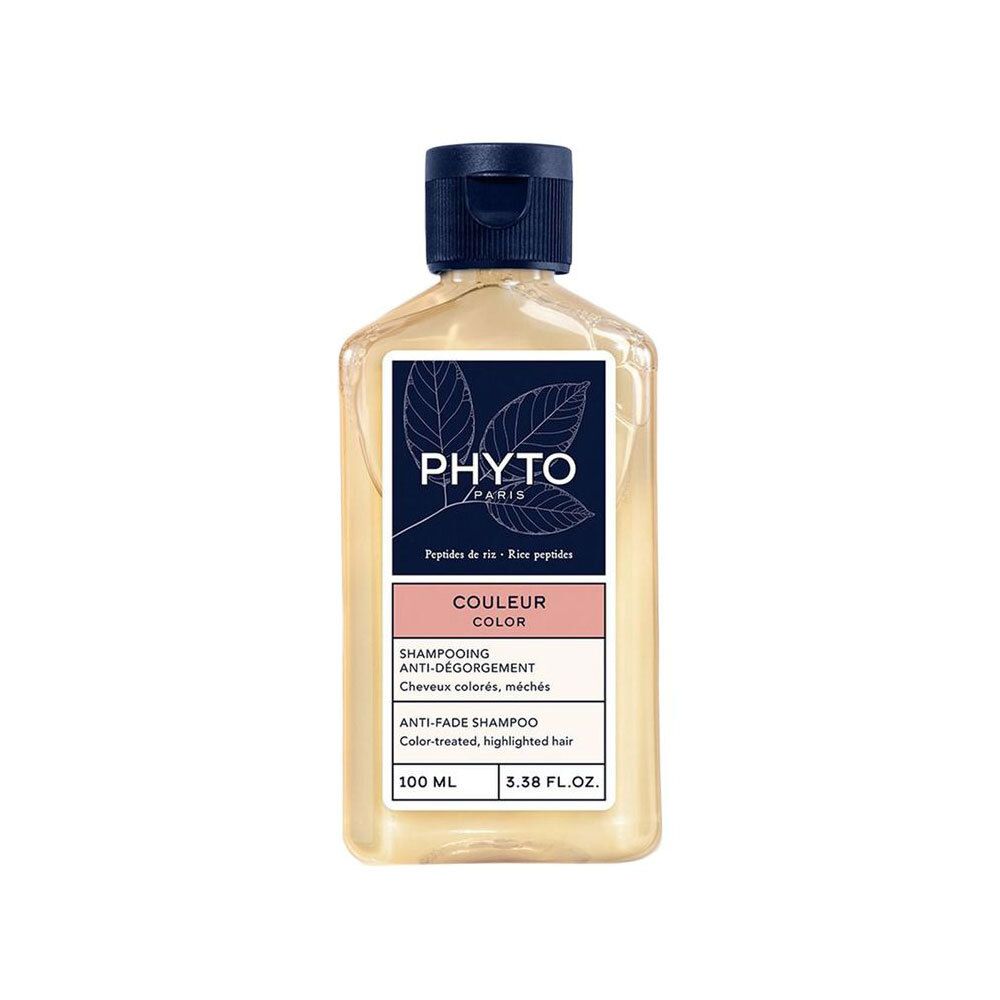 Flacon de shampooing avec étiquette. Nom du produit et marque visibles. Bouchon bleu. Liquide transparent.