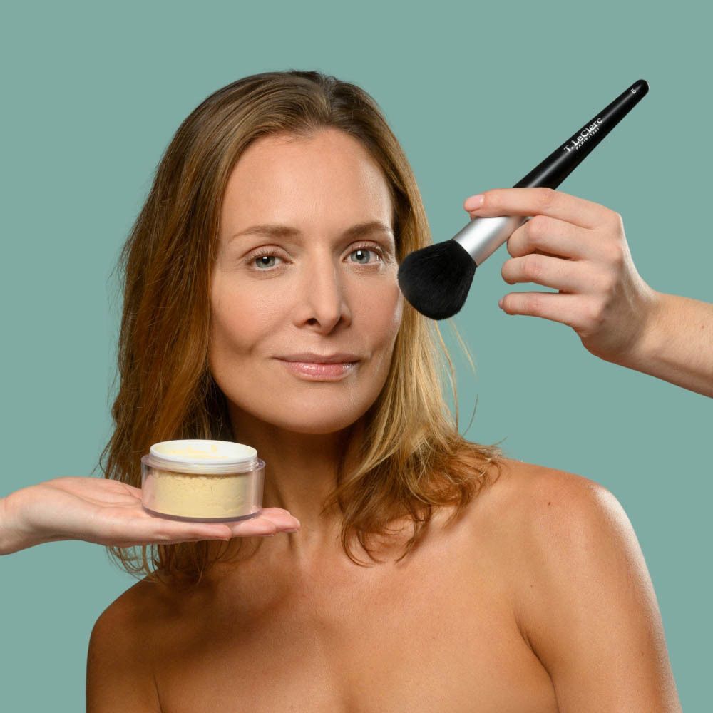 Femme avec pinceau et poudrier. Application de poudre. Produit: Poudre de Riz Dermophile.