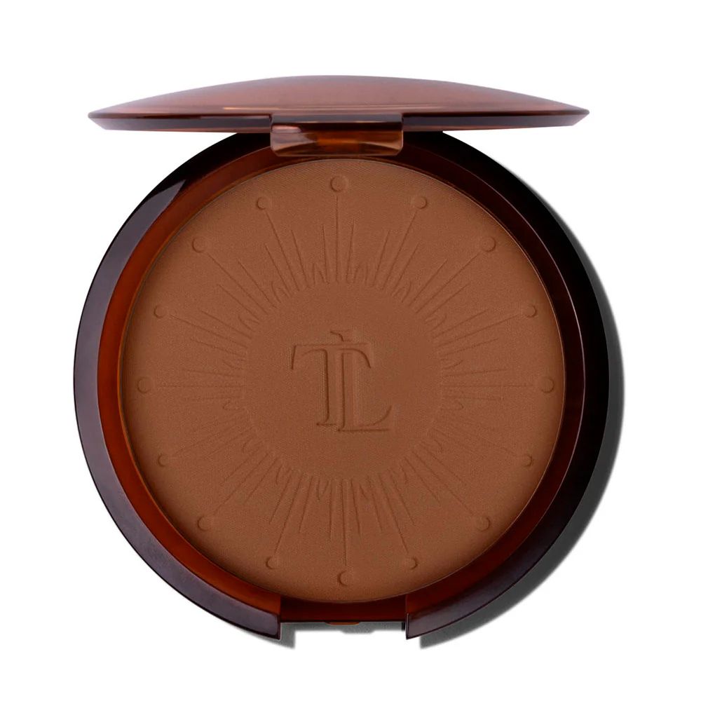 Poudre bronzante compacte ronde dans un étui marron. Logo et motif à l'intérieur. Couvercle ouvert.