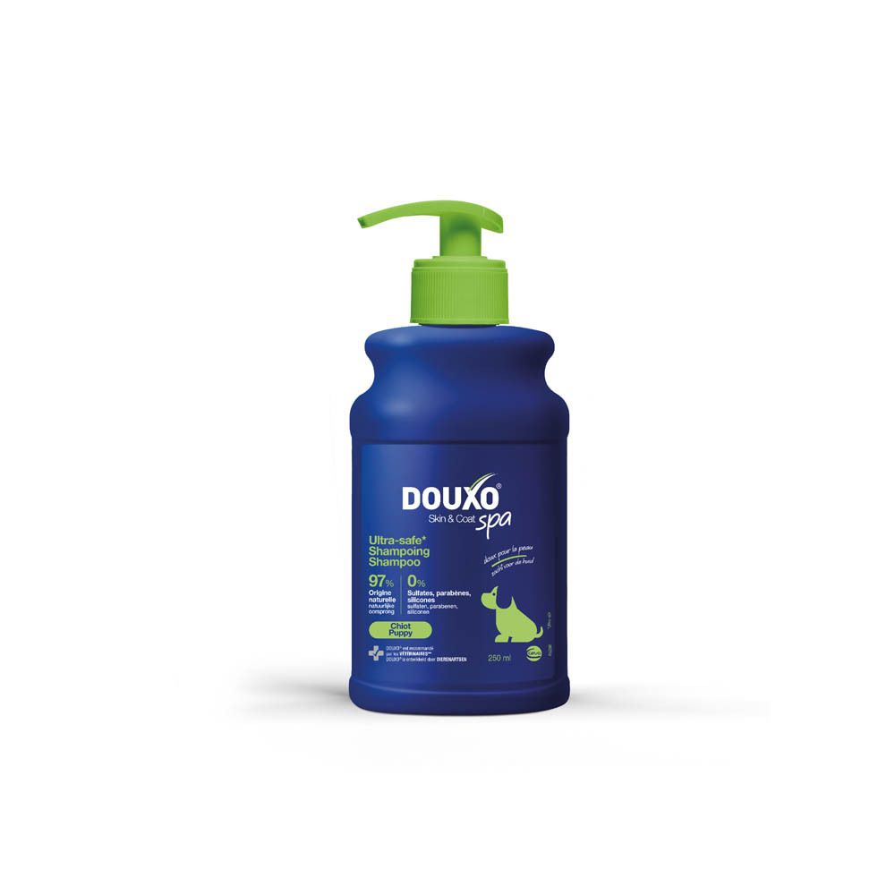 Flacon bleu et blanc avec pompe verte. Inscription: Douxo Spa Ultra-safe Shampooing Chiot.