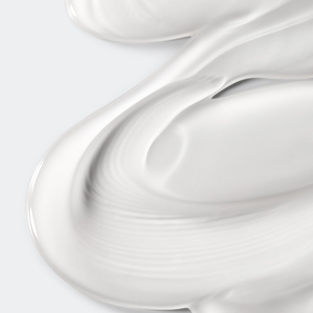 Gros plan de crème blanche. La crème est ondulée et a une texture lisse.