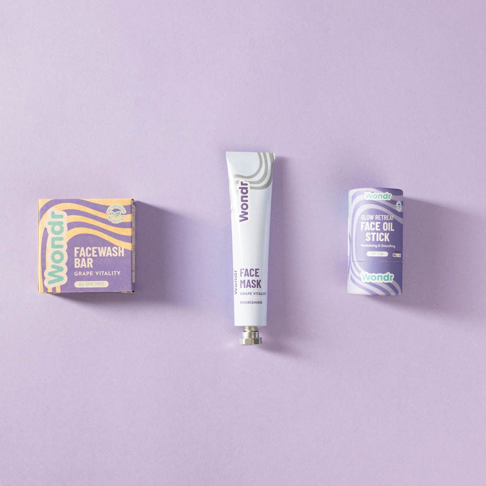 Trois produits sur fond violet. Tube, boîte et roll-on. Inscription : Wondr.