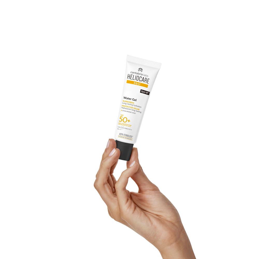 Main tenant un tube Heliocare 360° Water Gel SPF50+. Texte : Écran solaire, SPF 50+.