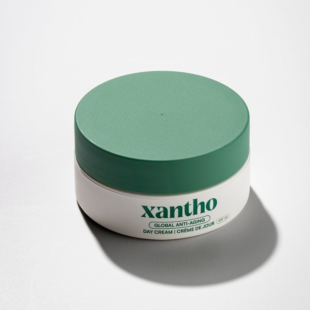 Crème de jour anti-âge Xantho FPS 20, pot blanc avec couvercle vert, sur fond blanc.