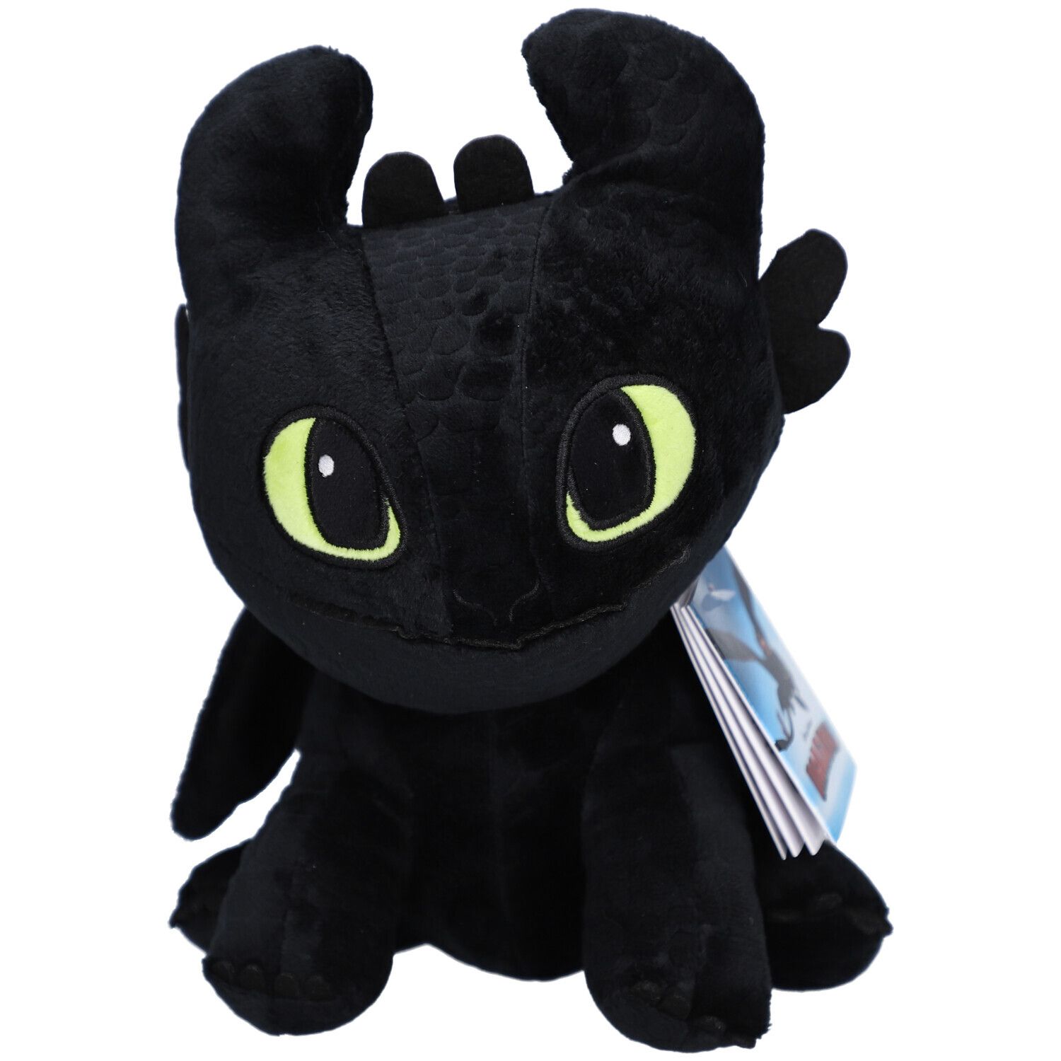 Peluche noire en forme de dragon avec des yeux jaunes. Le jouet en peluche a des oreilles, des ailes et une étiquette.