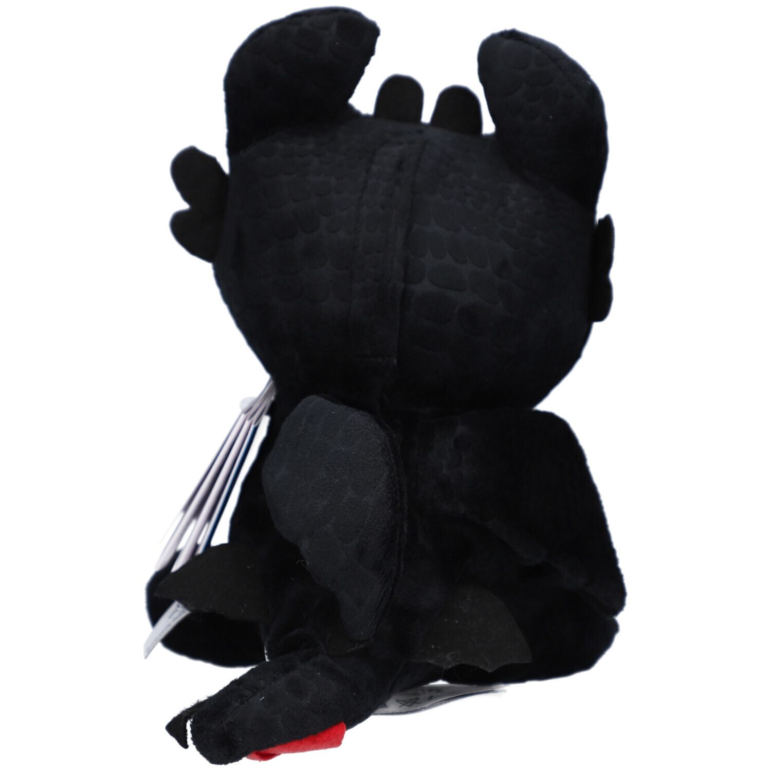 Vue arrière d'une peluche noire en forme de dragon. Ailes, oreilles et un accent rouge sont visibles.