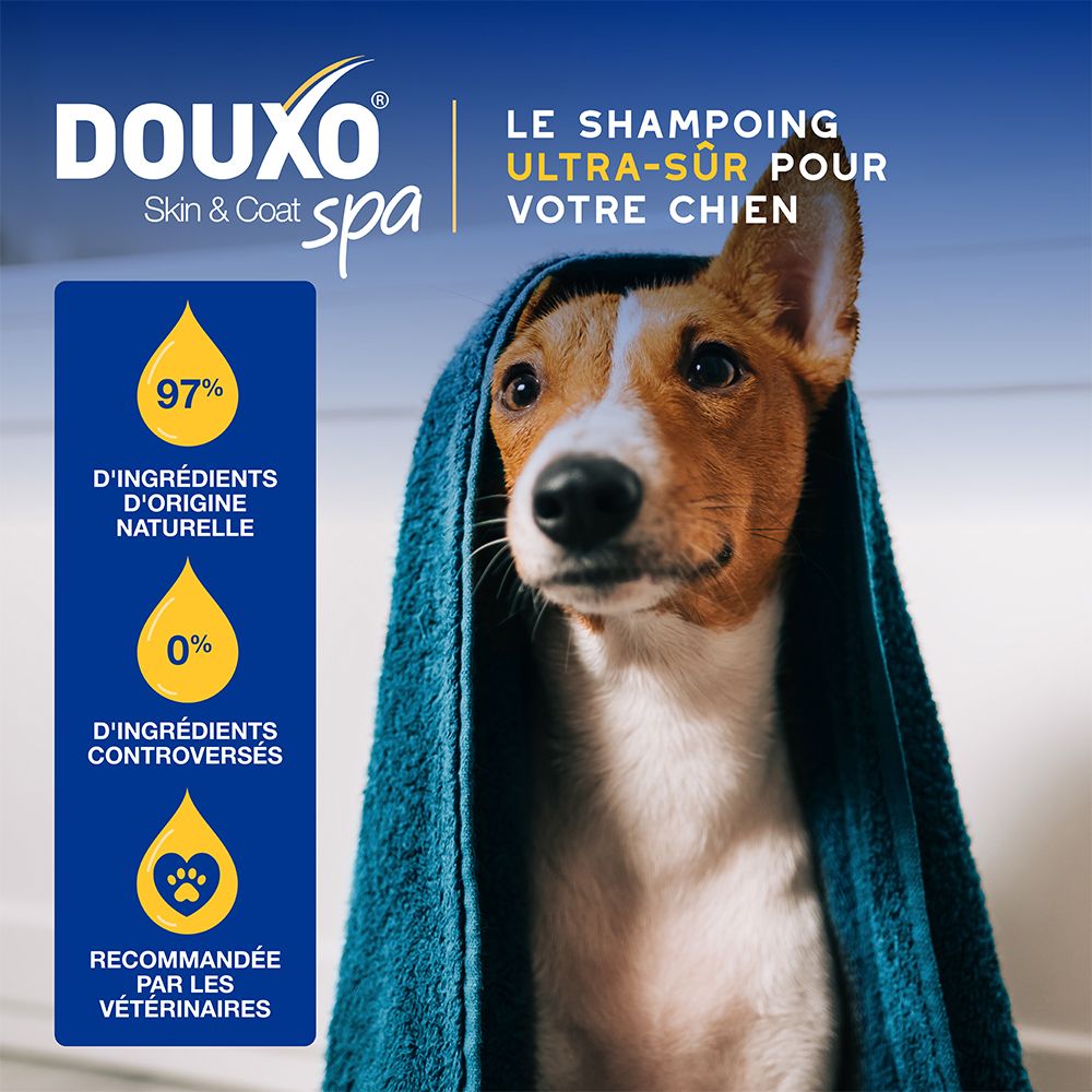 Chien avec une serviette. Texte: DOUXO Skin & Coat spa. Le shampooing ultra-sûr pour votre chien.