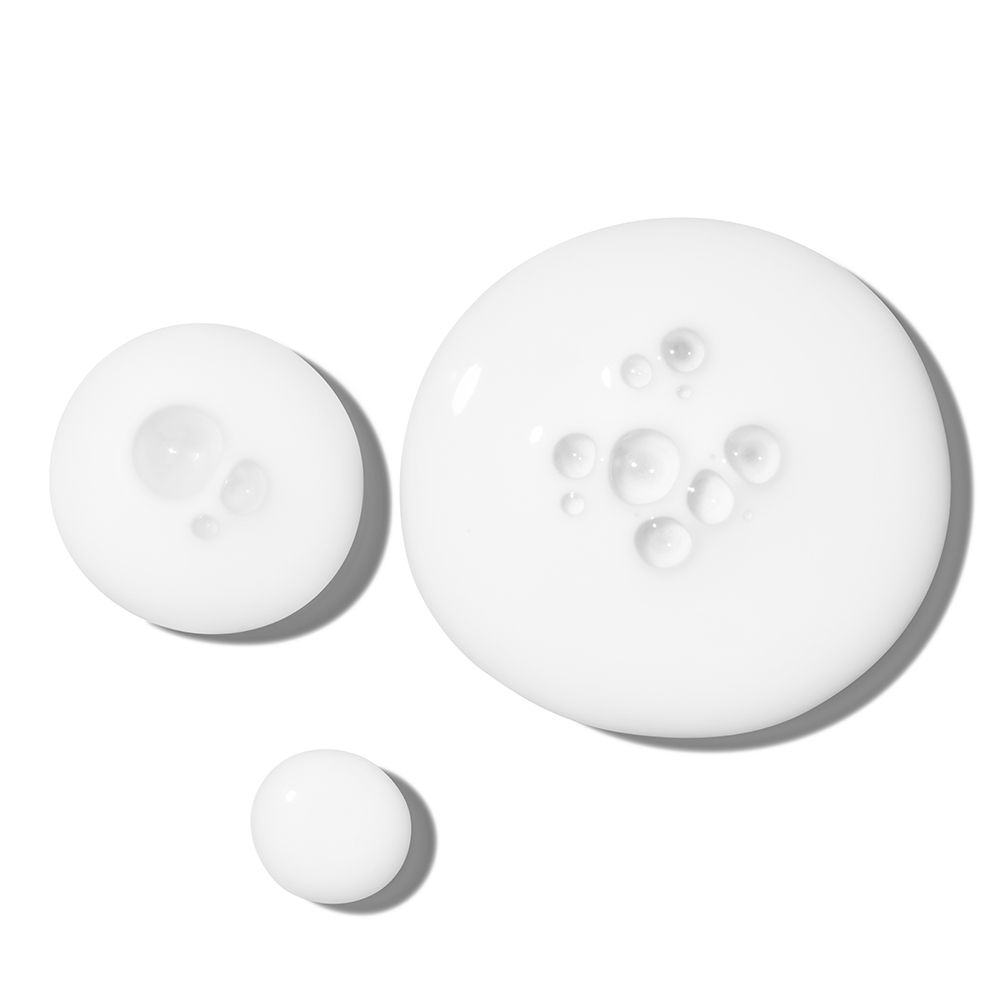 Trois gouttes de liquide blanc. Quelques petites bulles visibles.