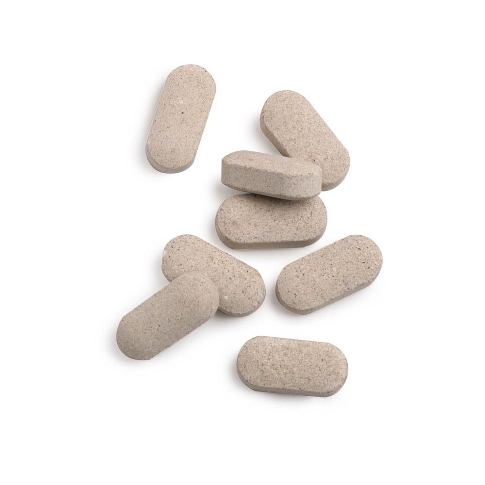 Plusieurs comprimés. Comprimés oblongs brun clair. Sur fond blanc.