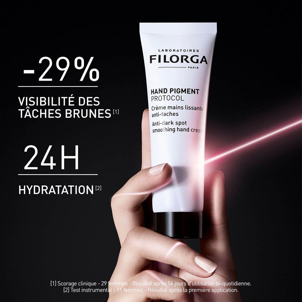 Tube blanc Filorga Hand Pigment Protocol. Crème mains anti-taches. Main avec tube. -29% Visibilité des taches brunes.