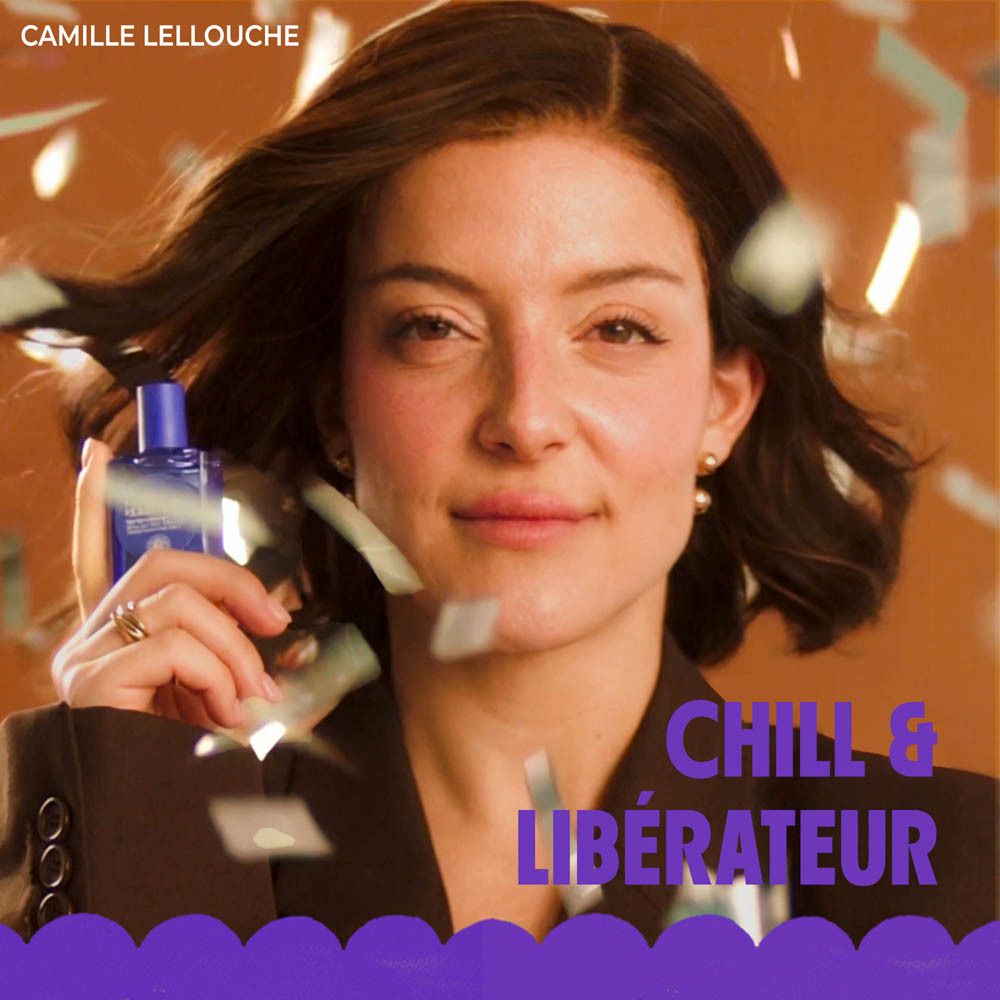 Femme tenant un parfum roll-on. Texte: Chill & Libérateur.
