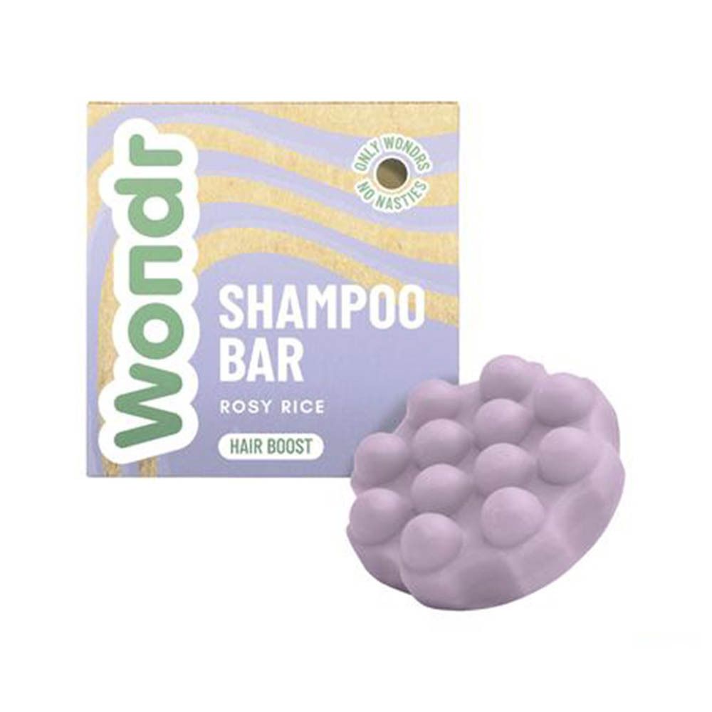 Emballage Wondr Shampoo Bar Rosy Rice à côté d'un pain de shampoing lilas texturé.