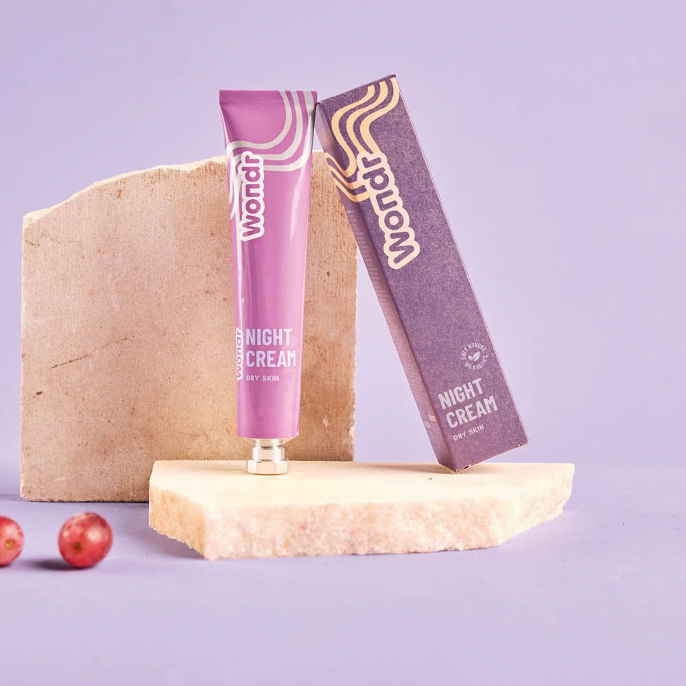 Tube et boîte. Tube lilas avec inscription blanche "Wondr" et "Night Cream Dry Skin".